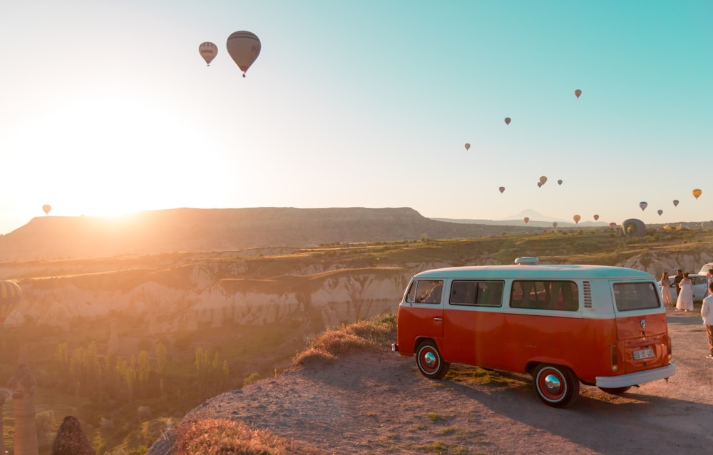 red and white volkswagen t-2 on brown rocky mountain during daytime