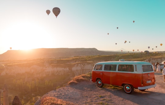 red and white volkswagen t-2 on brown rocky mountain during daytime in Cappadocia Turkey