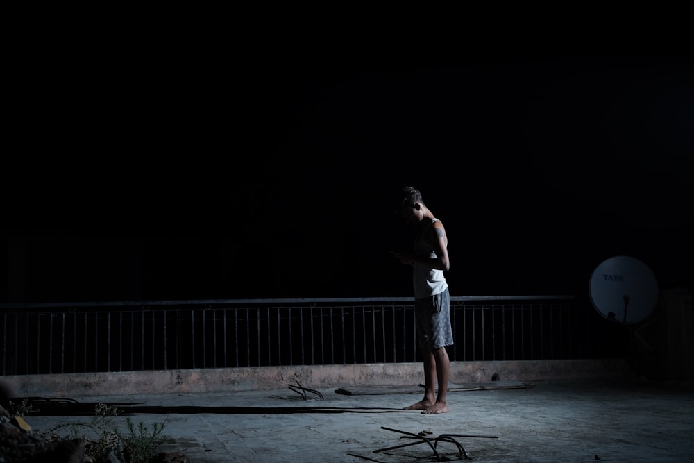 woman in white tank top and white shorts standing on gray concrete floor during nighttime