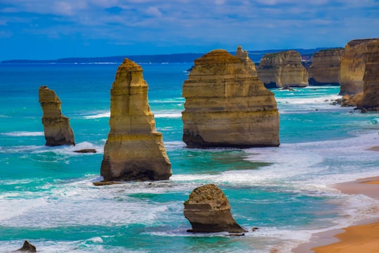 brown rock formation on blue sea under blue sky during daytime in Twelve Apostles Australia