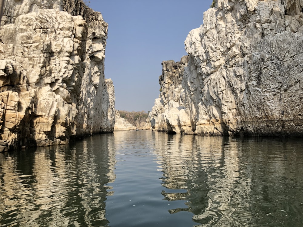 brown rocky mountain beside body of water during daytime