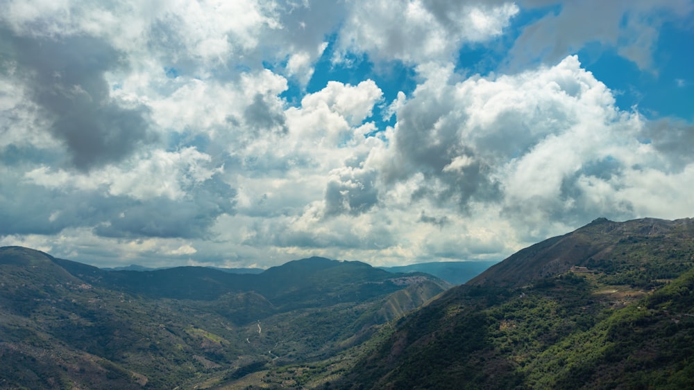 green mountains under white clouds and blue sky during daytime