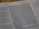 A close-up view of a book page showing printed text and a small section with handwritten notes on the side. The text includes numbers and is formatted in paragraphs.