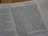A close-up view of a book page showing printed text and a small section with handwritten notes on the side. The text includes numbers and is formatted in paragraphs.