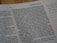 A close-up view of a book page showing printed text and a small section with handwritten notes on the side. The text includes numbers and is formatted in paragraphs.