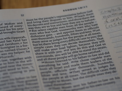 A close-up view of a book page showing printed text and a small section with handwritten notes on the side. The text includes numbers and is formatted in paragraphs.