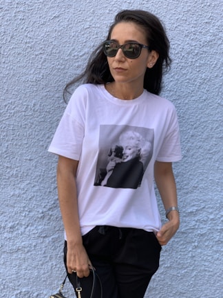 Close-up of a model wearing a black oversized Taurus Mindset t-shirt against a textured concrete wall.
