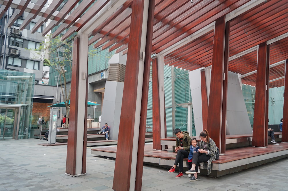 a group of people sitting on top of a wooden bench