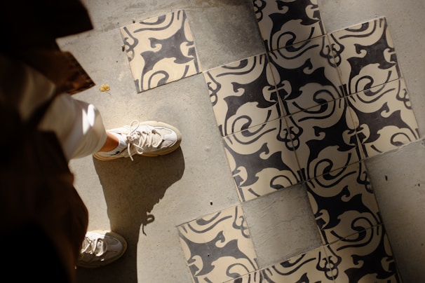 A pair of bold patterned sneakers placed on a concrete floor with soft shadows.