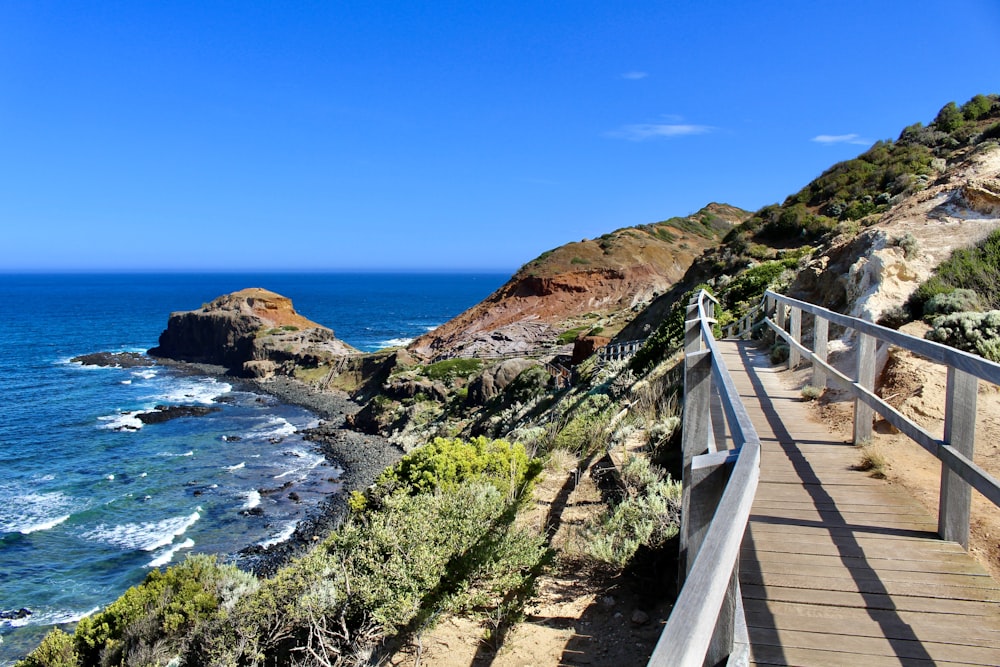 white wooden bridge on blue sea under blue sky during daytime