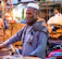 Portrait of a smiling Indian man standing in front of his small shop.