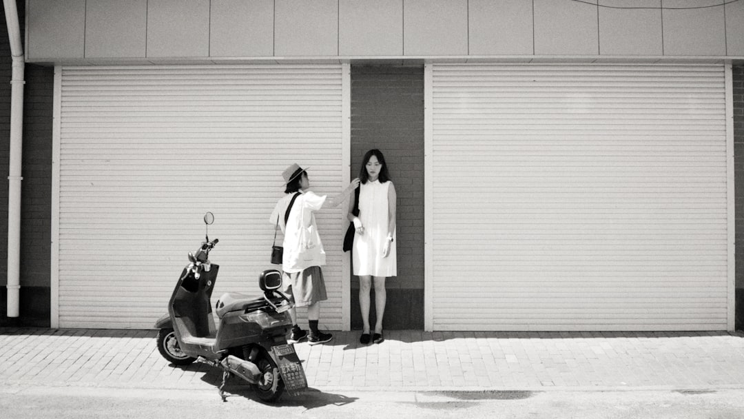 woman in white dress standing beside black motorcycle