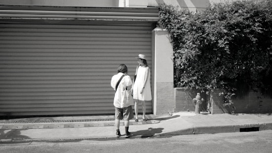 man in white dress shirt and black pants walking on sidewalk during daytime