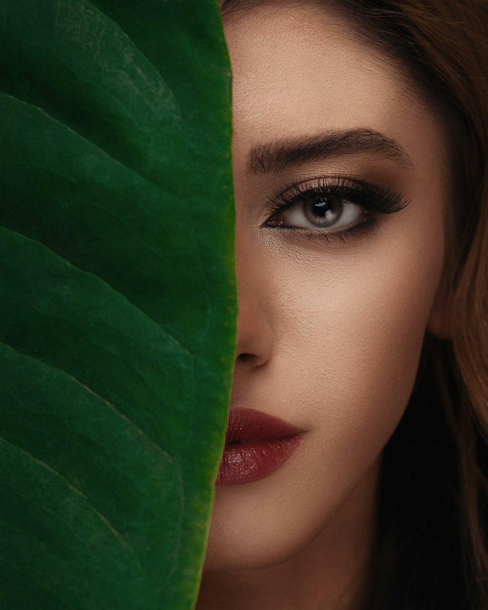 woman in red lipstick beside green textile