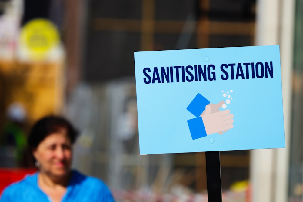 man in blue shirt holding white and black no smoking sign