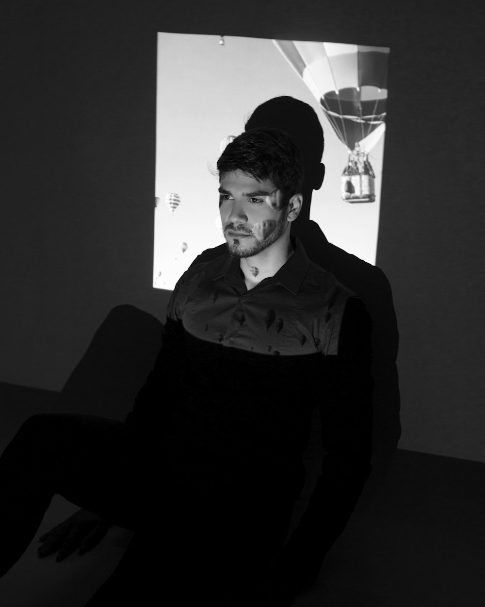 man in black dress shirt sitting on chair