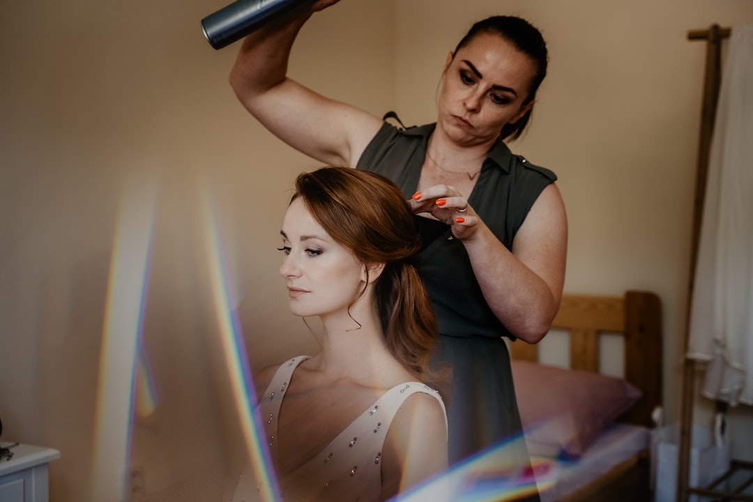 woman in black sleeveless dress holding hair dryer