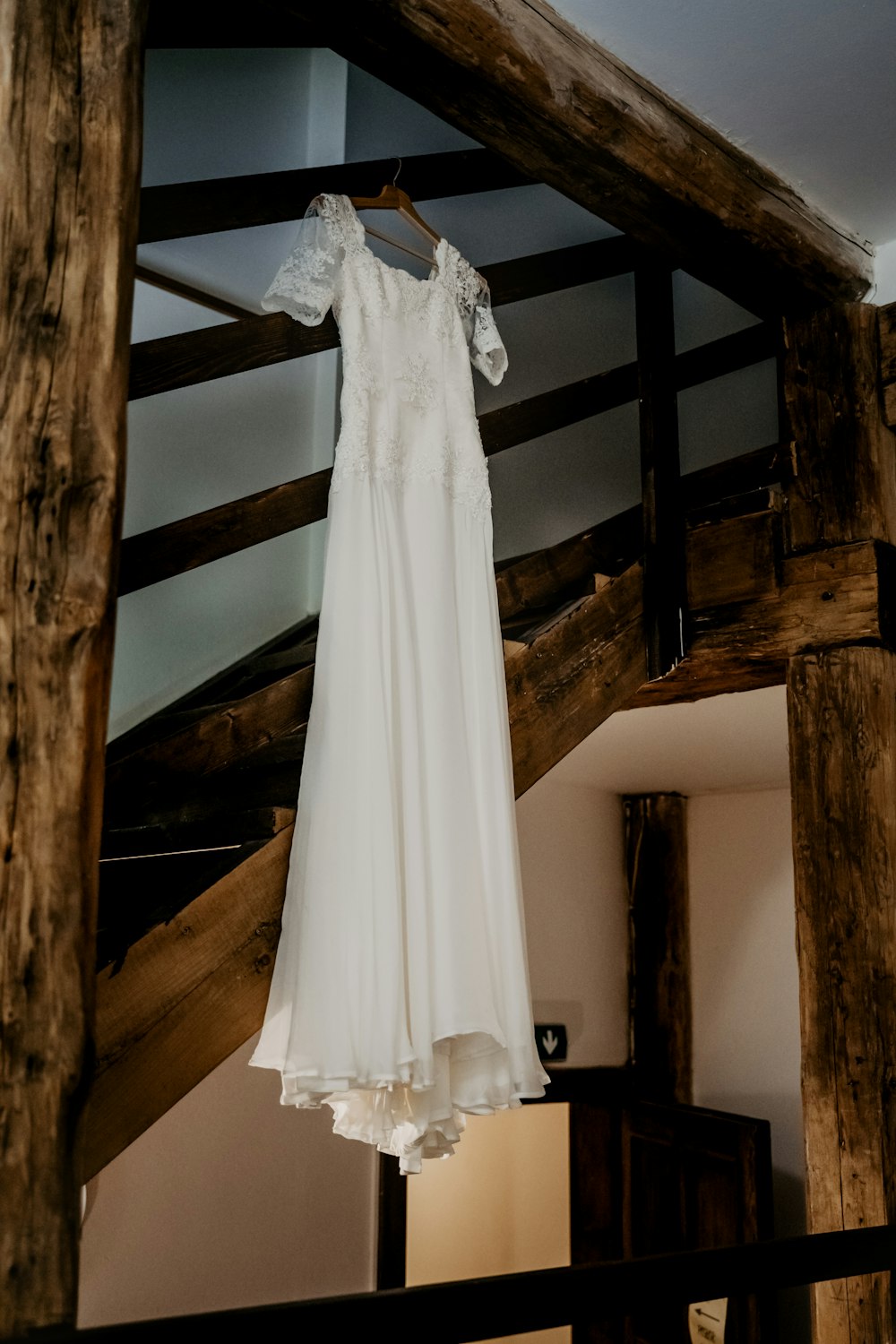 white dress hanged on brown wooden door