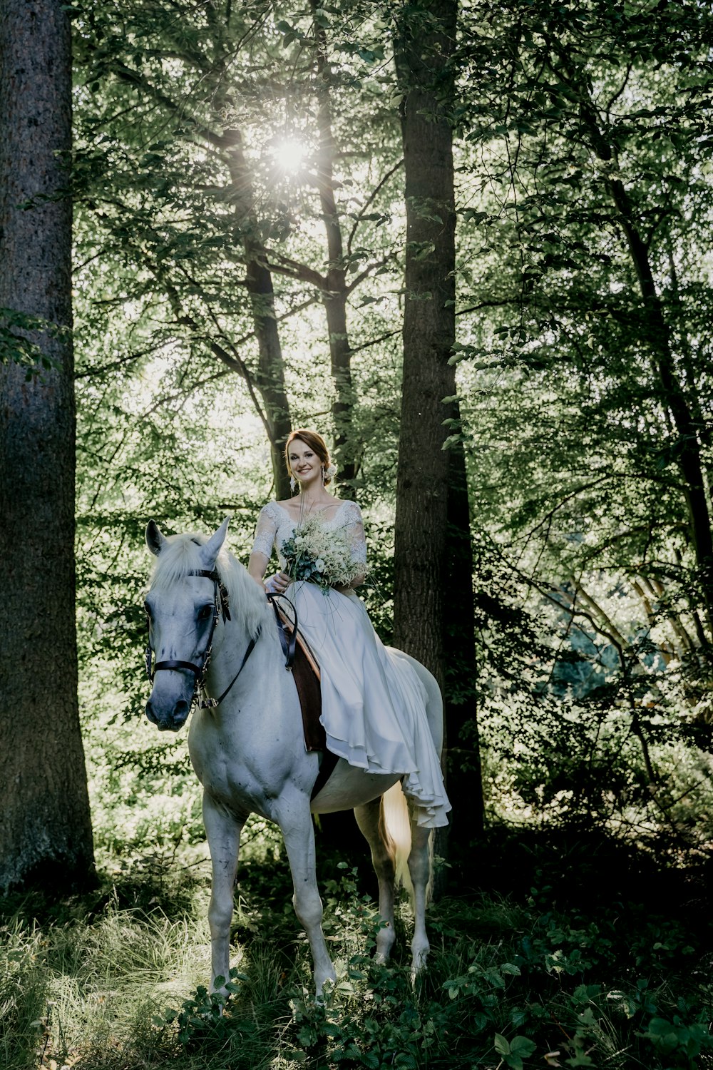 woman in white dress standing beside white horse