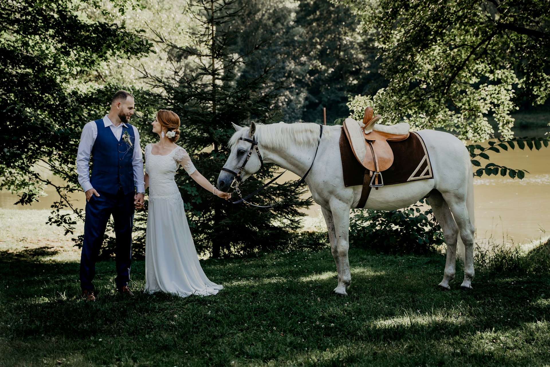 woman in white wedding gown standing beside man in blue dress shirt