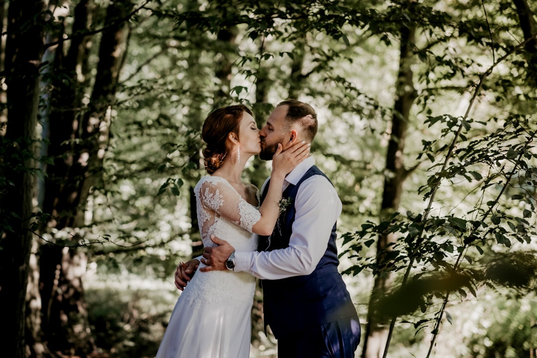 man and woman kissing in forest during daytime
