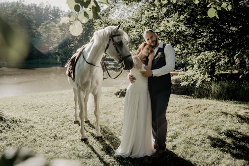 man and woman standing beside horse during daytime