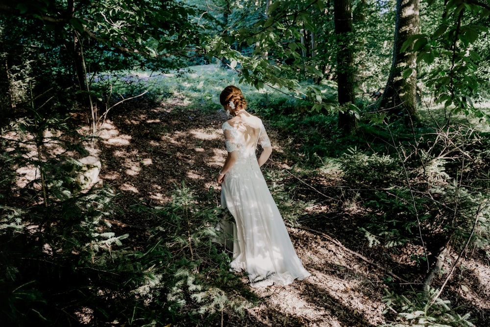 woman in white dress standing on forest during daytime