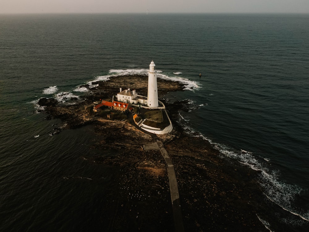 white lighthouse near body of water during daytime