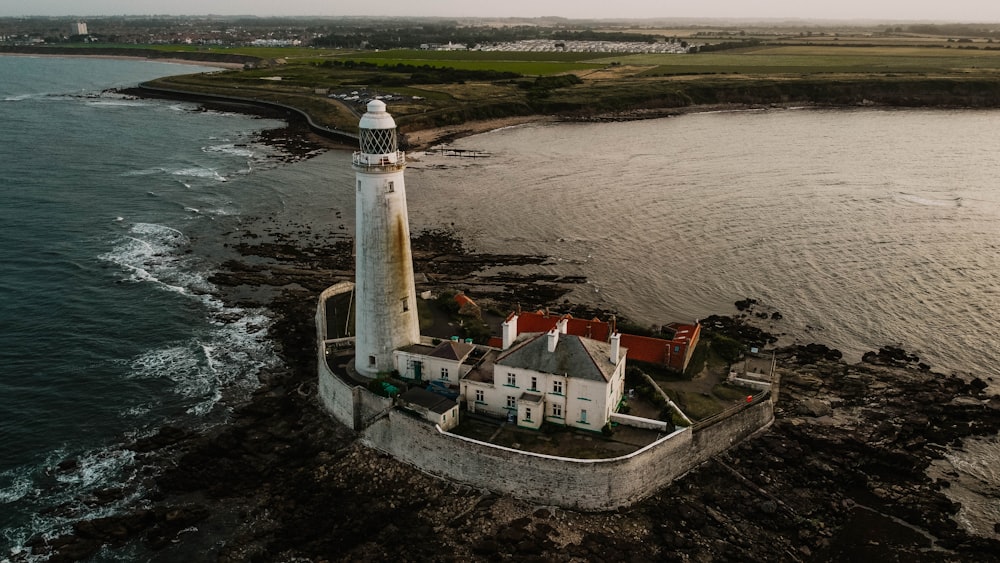 white and brown lighthouse near body of water during daytime