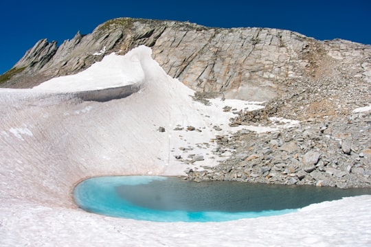 white ice formation on blue body of water during daytime in Pizzo Gallina Switzerland