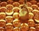 A golden hand positioned in a gesture commonly associated with meditation, surrounded by numerous shiny circular discs that create a textured backdrop. The discs reflect light, contributing to a luminous and harmonious visual effect.