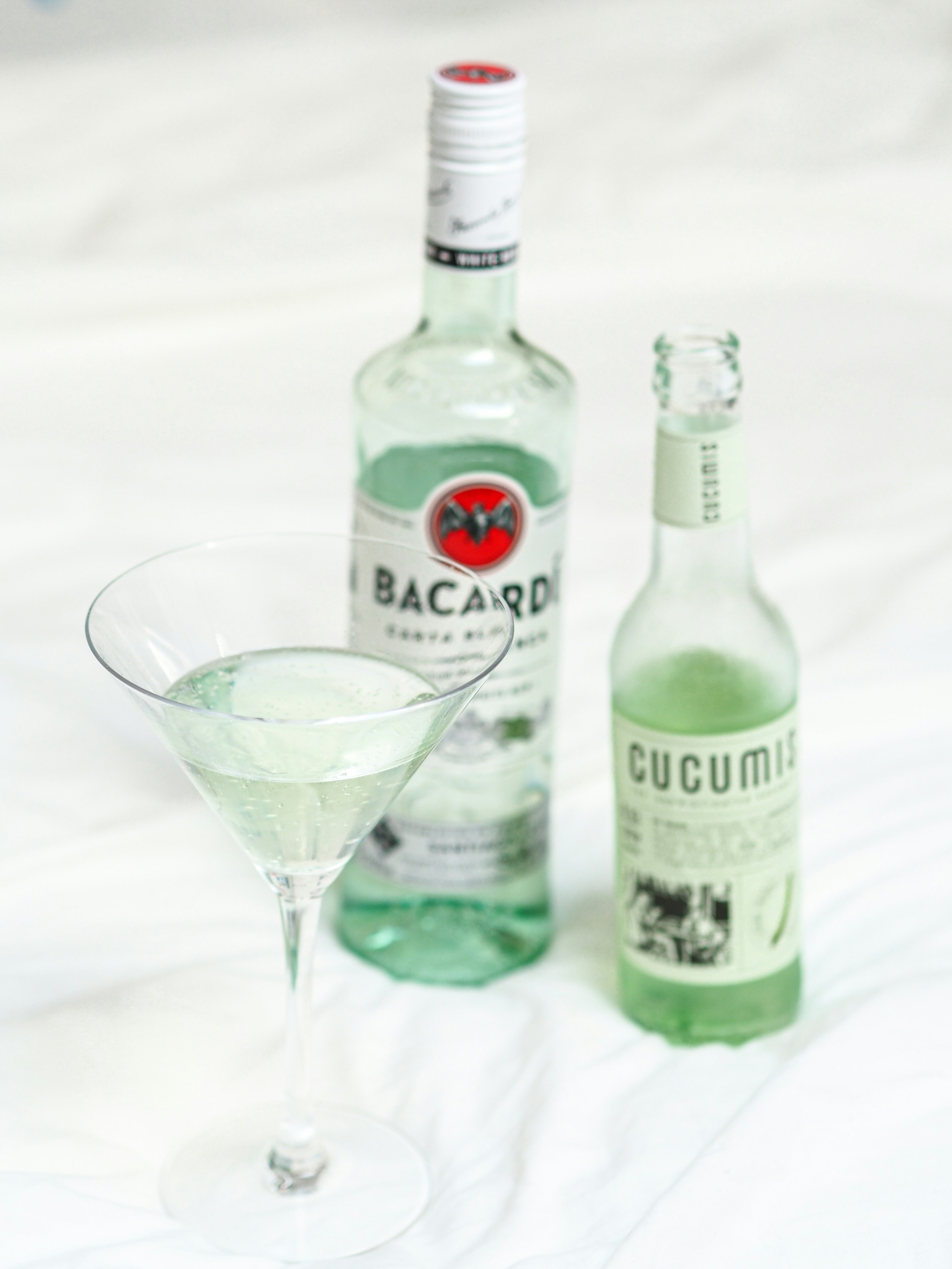 deux bouteilles en verre vert à côté d’un verre à boire transparent