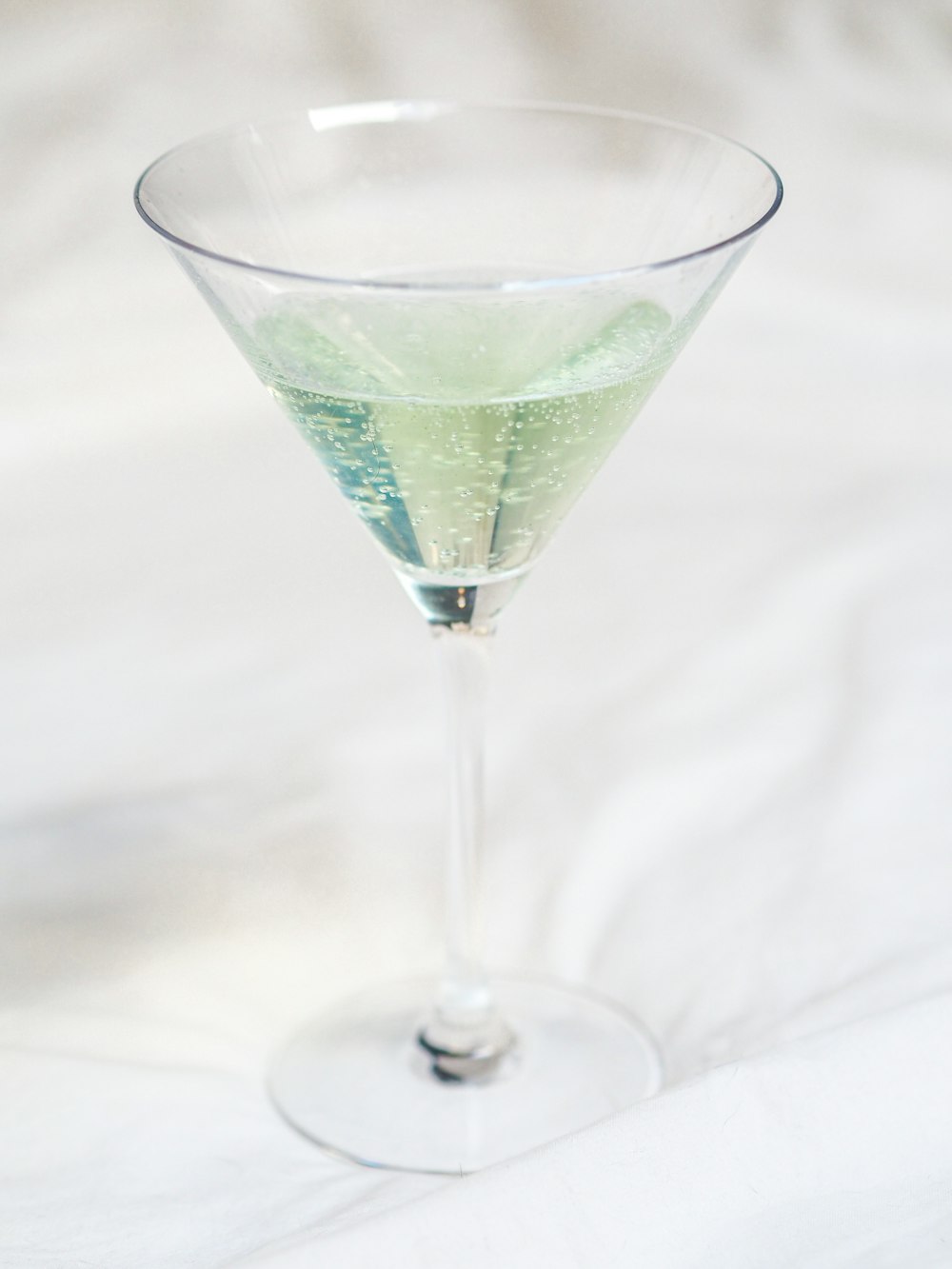 clear cocktail glass with green liquid