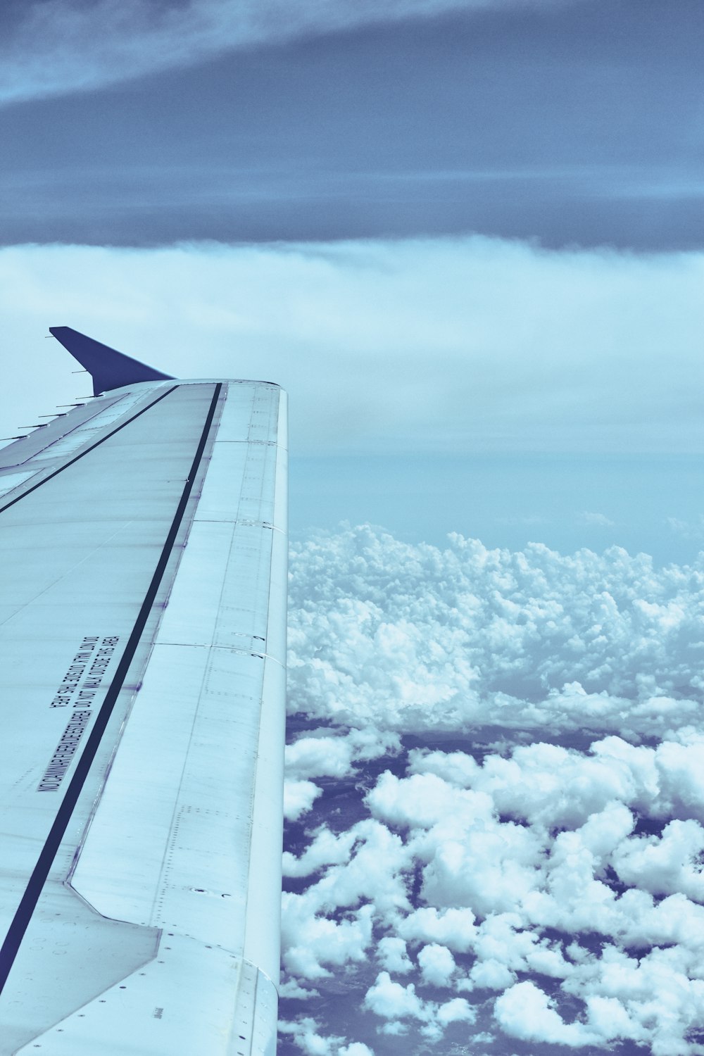 white airplane wing over white clouds during daytime