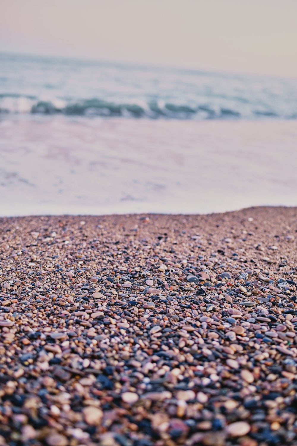 brown and black pebbles near body of water during daytime