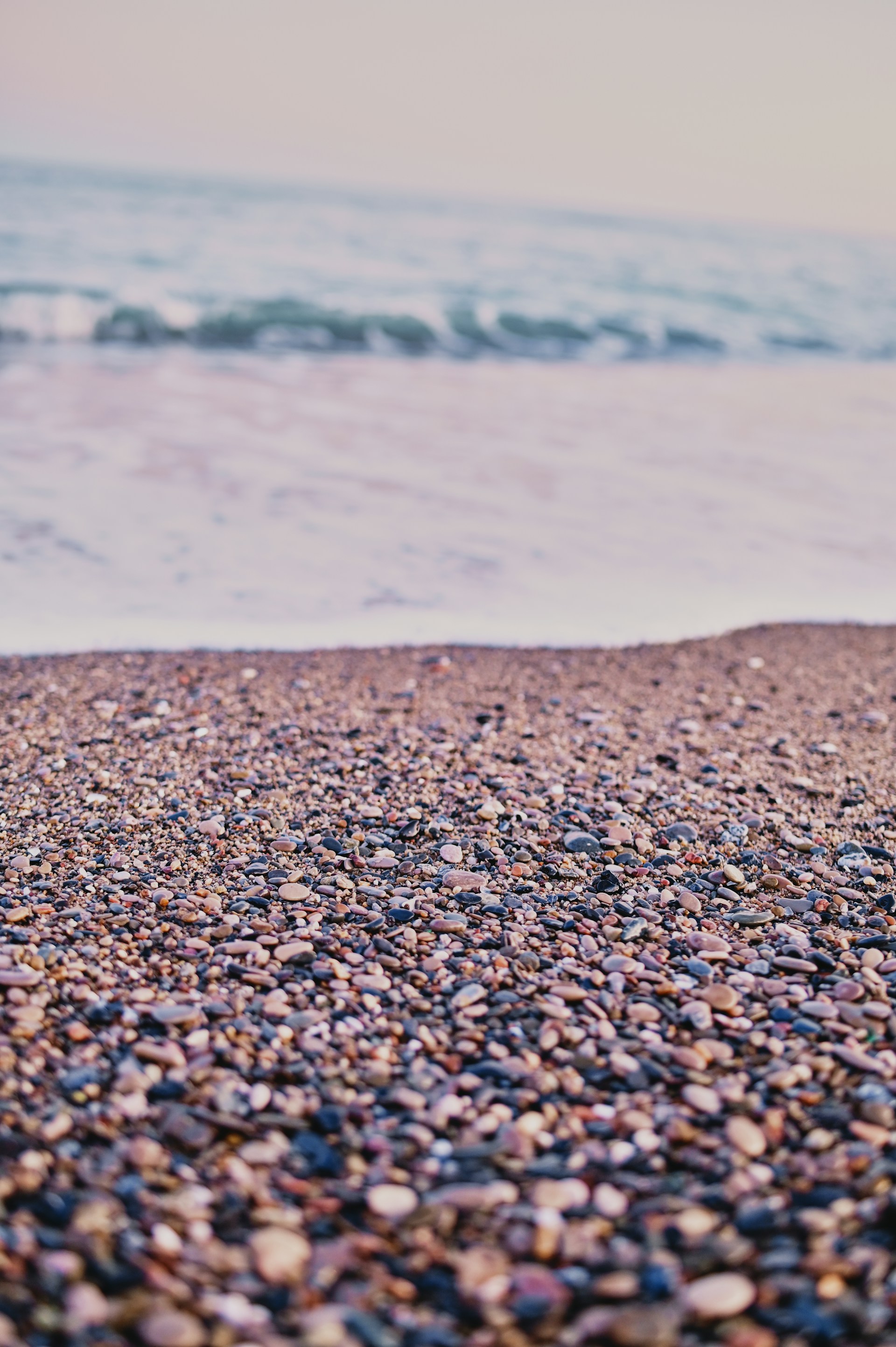 brown and black pebbles near body of water during daytime