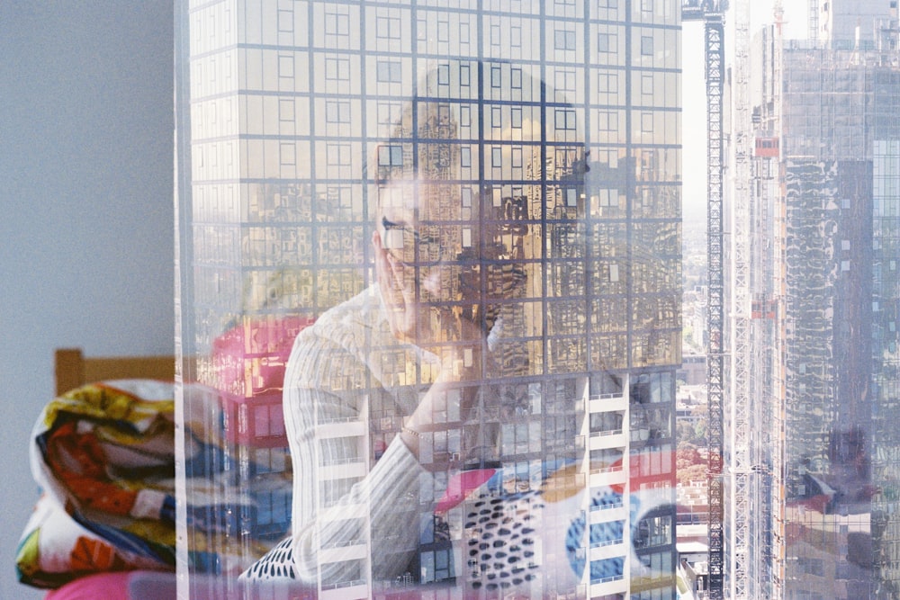 man in white long sleeve shirt standing in front of glass building