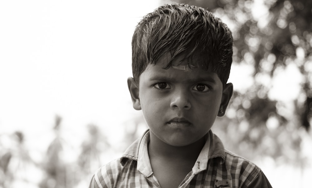 grayscale photo of boy in plaid shirt