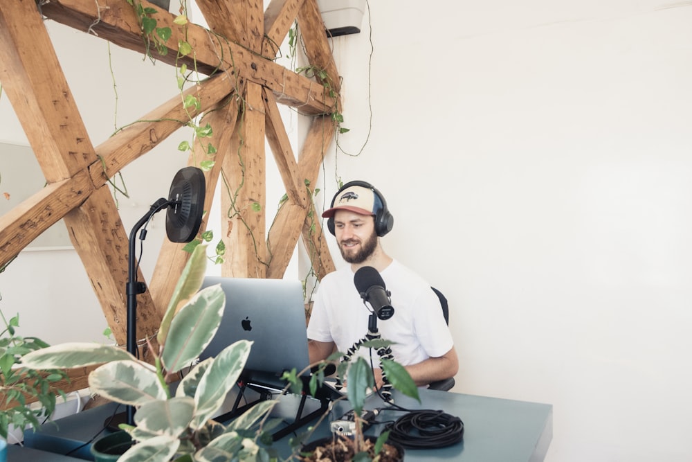 man in white crew neck t-shirt wearing black headphones