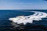 A sleek yacht gliding across calm turquoise waters.