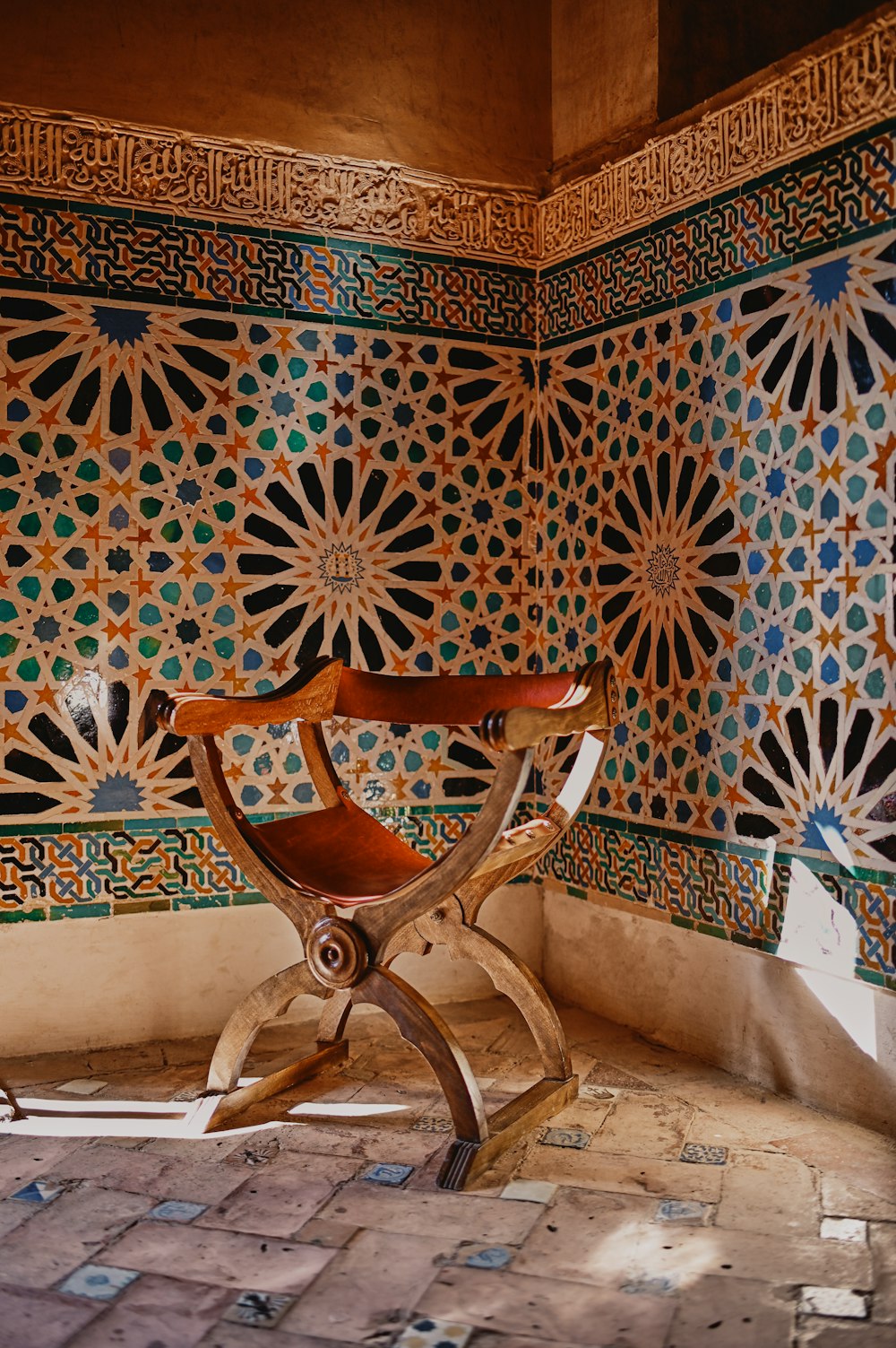 Chaise en bois marron à côté d’un mur floral blanc et bleu