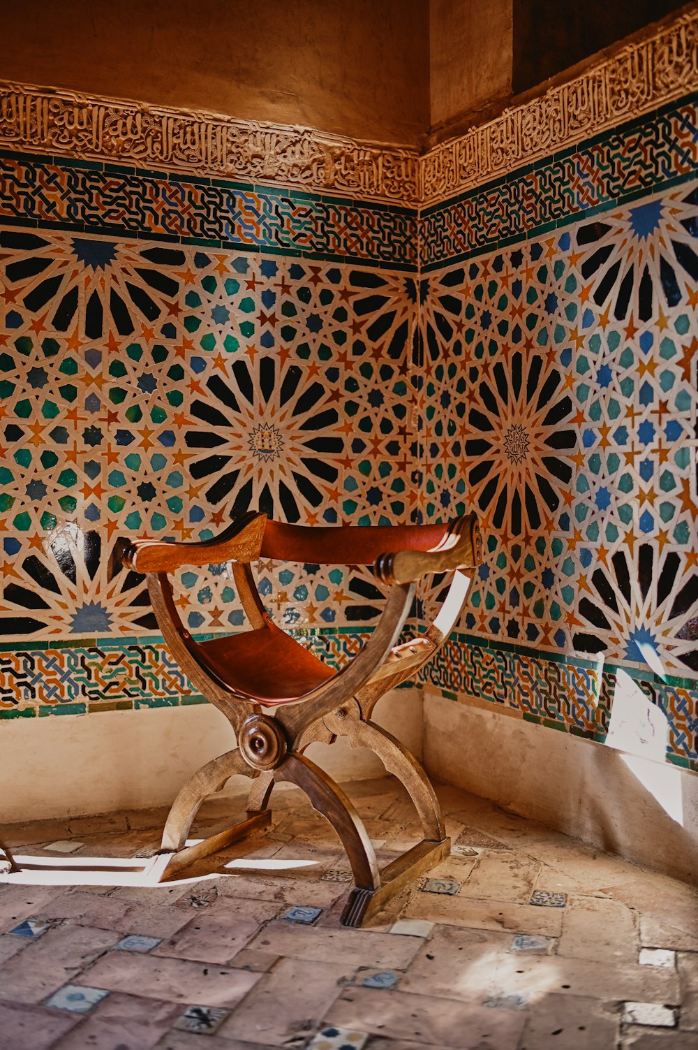 brown wooden chair beside white and blue floral wall