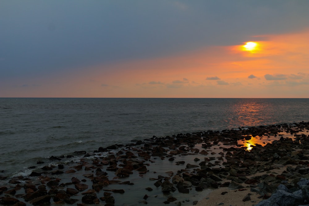 sea waves crashing on shore during sunset