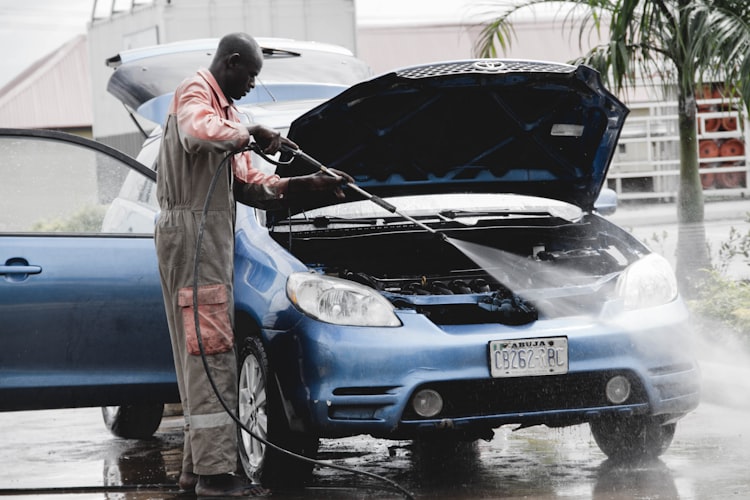Jet haute pression nettoyant la carrosserie d'une voiture avec mousse