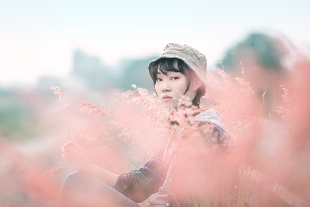 Femme au chapeau blanc avec de la poudre rose