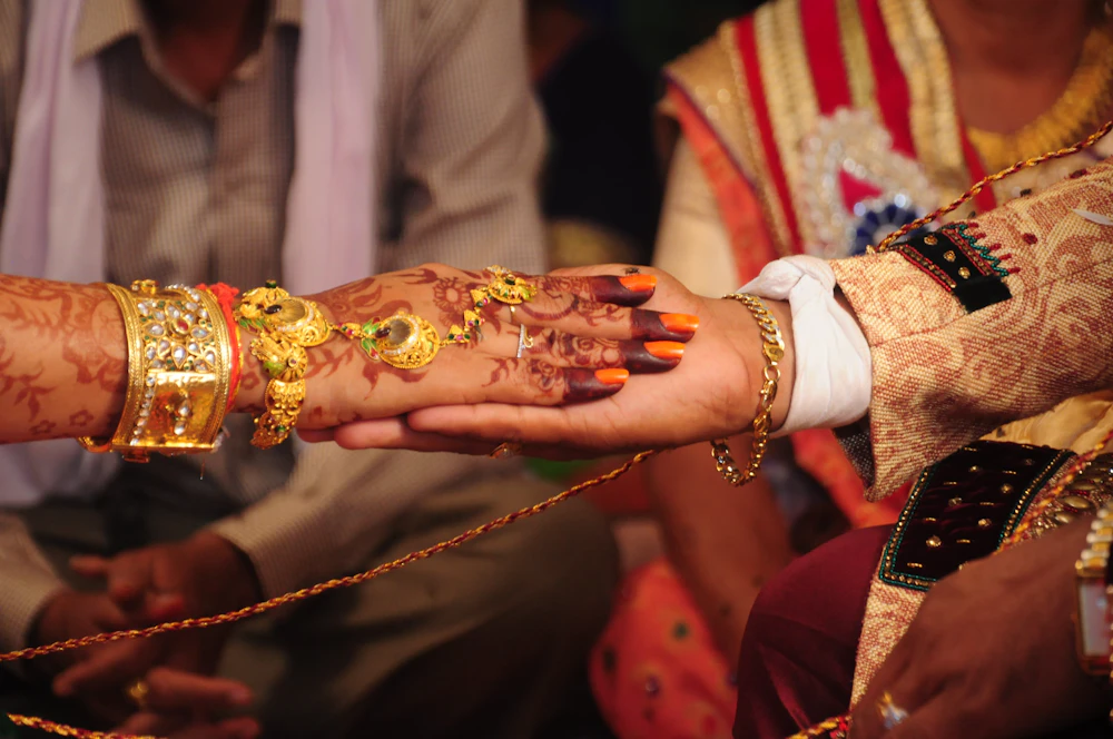 Groom holding a gold and red sehra before the baraat