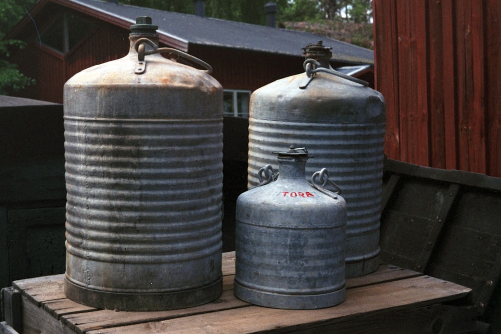 3 tanques de propano azul sobre piso de madera marrón
