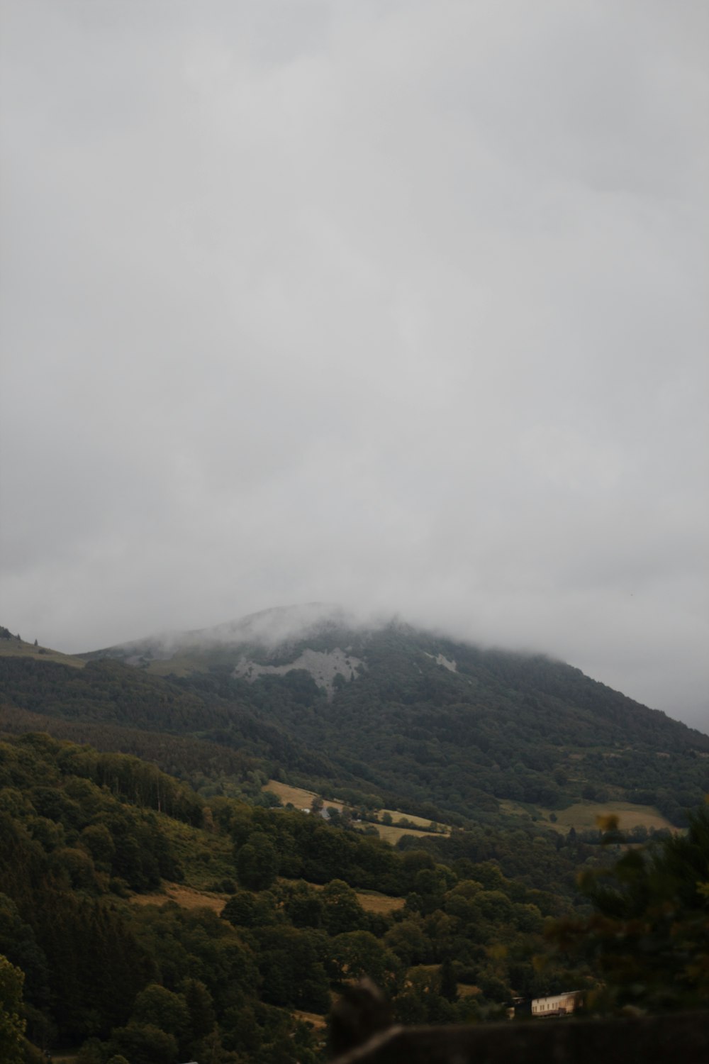 昼間の白い雲の下の緑と茶色の山々