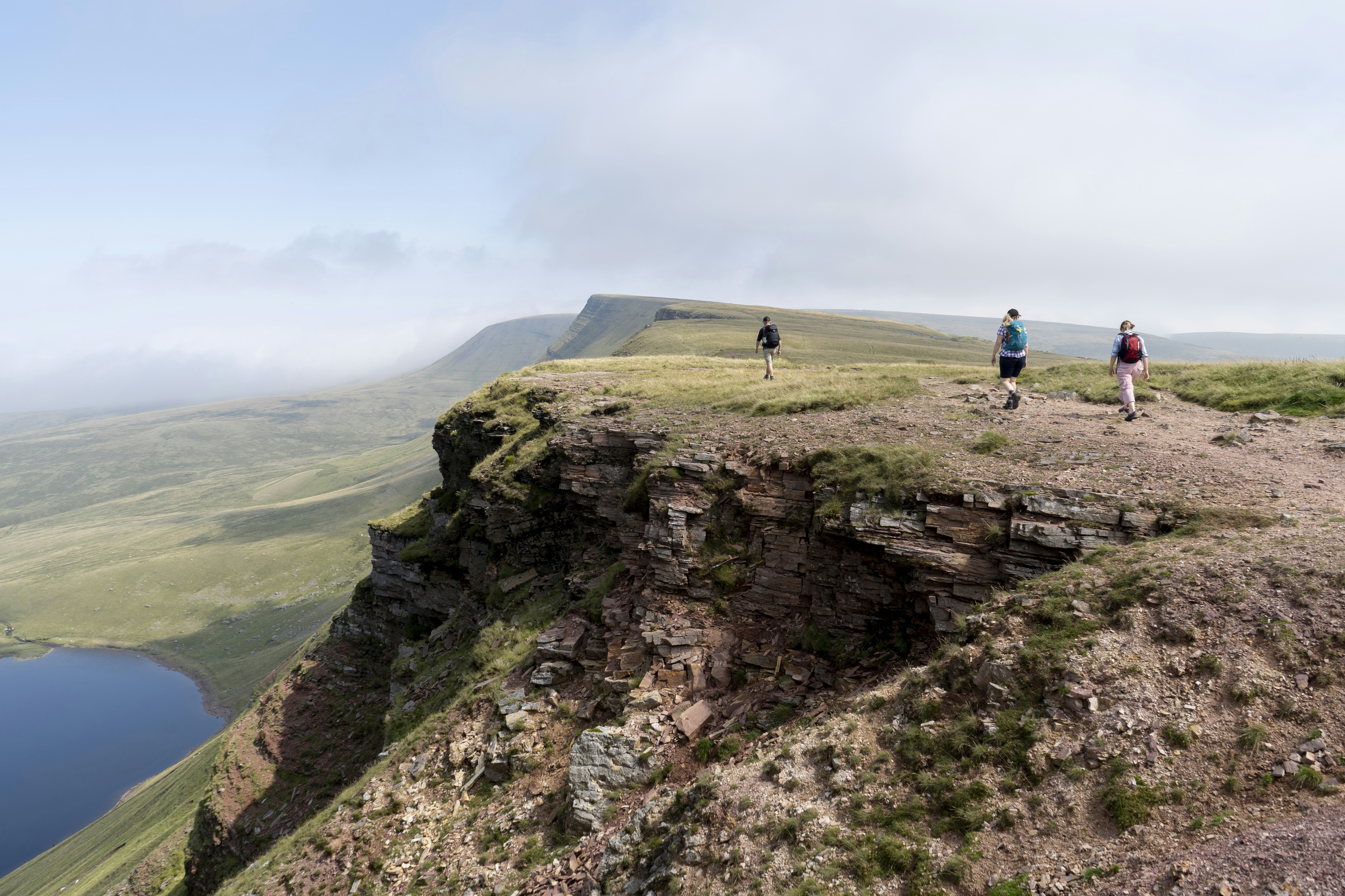 man in blue shirt and black pants walking on green grass field during daytime, Welsh mountain walk