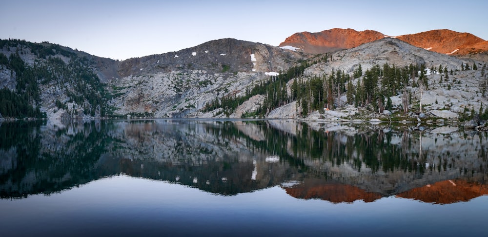 green and brown mountain beside body of water during daytime